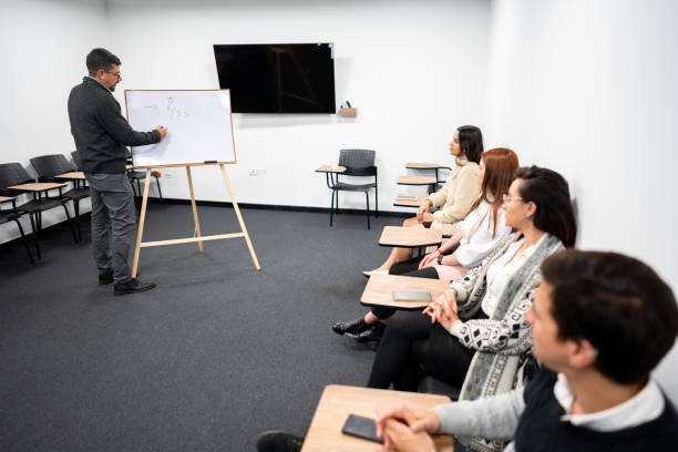 istock Recruiter explaining something on whiteboard to the candidates in the training classroom 1476787945