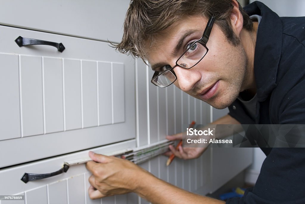 Home improvement - measuring Young guy measuring a kitchen 20-29 Years Stock Photo