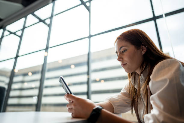 istock Young woman using mobile phone at office 1476790774