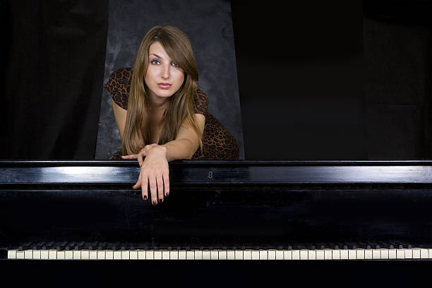 Beautiful girl on piano stock photo