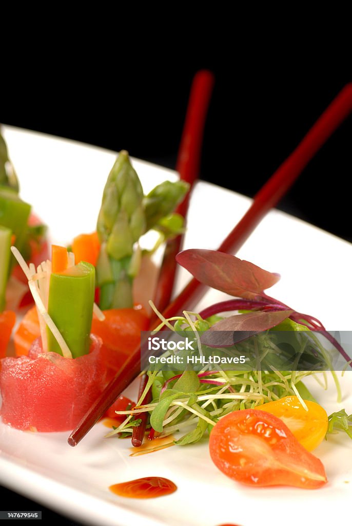 Sashimis deliciosos em um prato branco com corte de cenoura - Foto de stock de Alface royalty-free