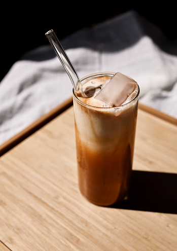 2 Different Iced Coffees with Paper Straws outdoors at Cafe.