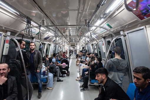 Picture of a metro of Istanbul Metro, on Line 2, with people sitting inside in crowd. The Istanbul Metro is a rapid transit railway network that serves the city of Istanbul, Turkey. It is operated by Metro Istanbul, a company, a public enterprise, controlled by the Istanbul Metropolitan Municipality.