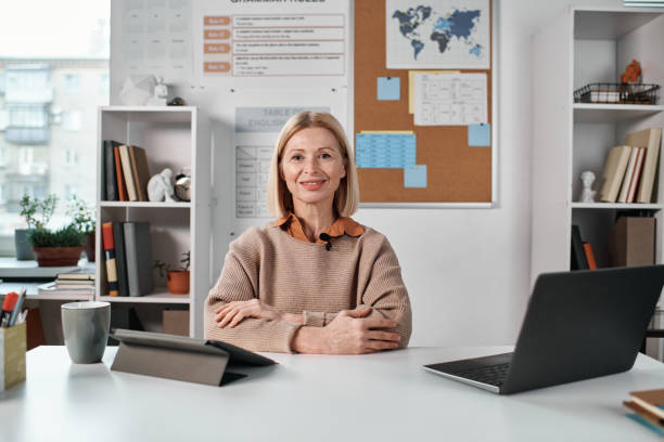 istock Teacher sitting at her workplace in classroom 1476799134
