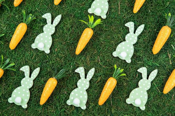 istock Easter pattern background made of decorative carrots and bunny rabbits on natural organic texture, 1476800308
