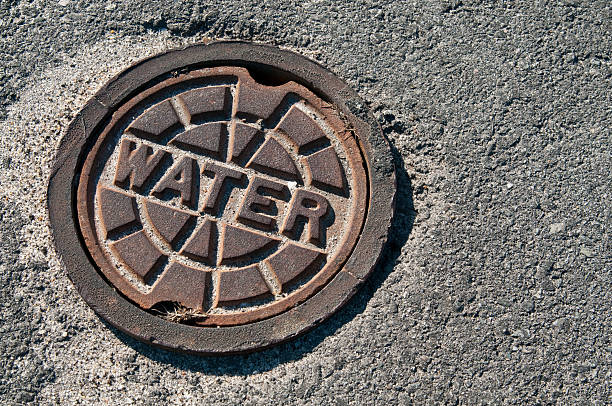 Sewage drain marked water on the cement road Street water access. manhole stock pictures, royalty-free photos & images