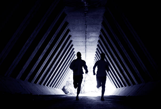 Powerful athlete sprinting and running. Man training and casting shadow in a wall.