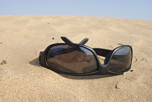 Sunglasses on a concrete seaside beach wall in evening spring sun