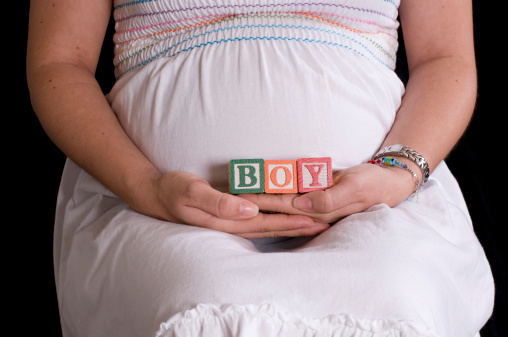Pregnant woman with alphabet cubes spelling Boy