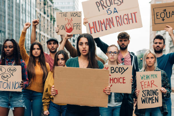 istock group of young activists holding panels protesting for equality gender and climate change - girl holding banner with copy space 1476810667