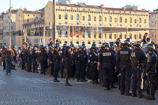 Marseille, France - March 23 2019: Policemen in riot gear with helmet and bulletproof vest at the Vieux Port.