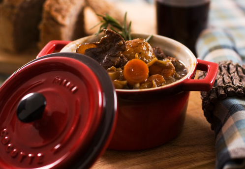 Vegetable and moose stew in a colorful red cocotte. Ready to eat meal.