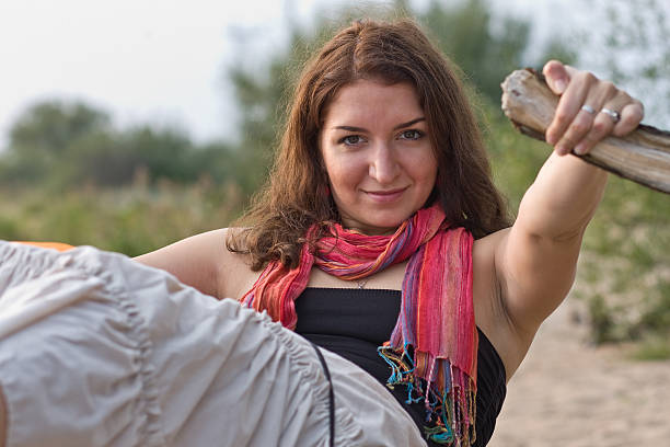 Young woman sitting on the branch stock photo