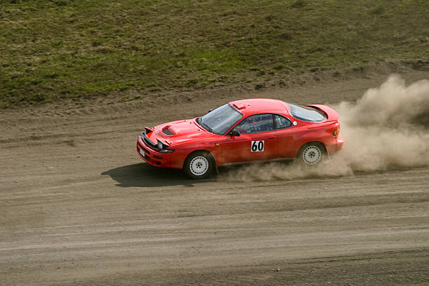 Red car racing down a dirt road Red rally car in a race rally car racing stock pictures, royalty-free photos & images