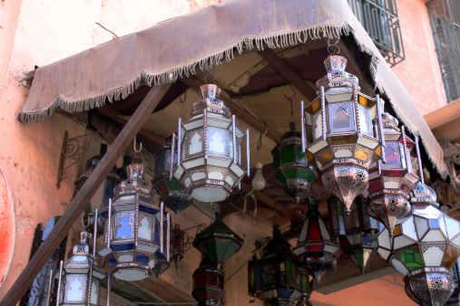 Glass and Metal lanterns hanging outside under an awning