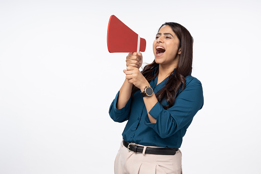 Businesswoman screaming by megaphone on white background