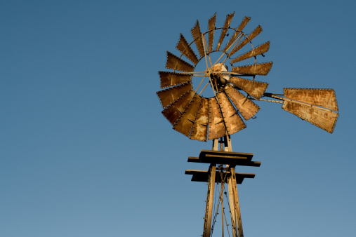 a windmill on a texas ranch at sunset.