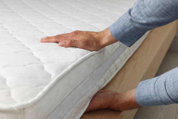 istock Man touching soft white mattress indoors, closeup 1476822113