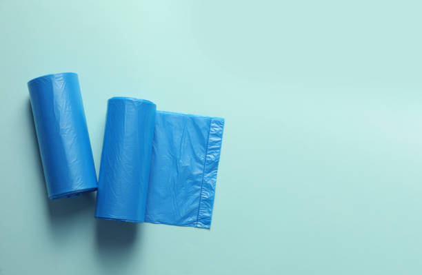 istock Rolls of turquoise garbage bags on light blue background, flat lay. Space for text 1476822256