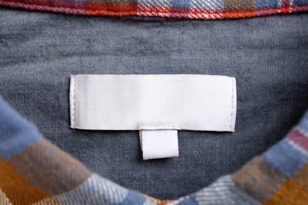 Blank clothing label on colorful apparel, top view