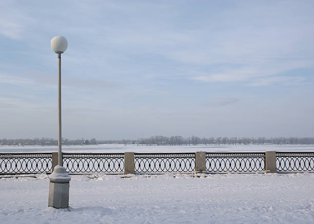 Street lamp on the embankment with parapet in winter stock photo