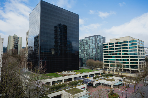 Office buildings in downtown Portland Oregon with a natural garden feature. Some of these buildings have rooftop gardens and plants growing in the skyline level. Urban sustainability concept.