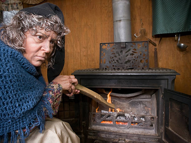 istock Old Woman Stokes Stove 147683340