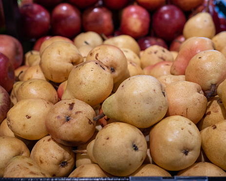 Very ripe pears, and appels, for sale in a grocery store