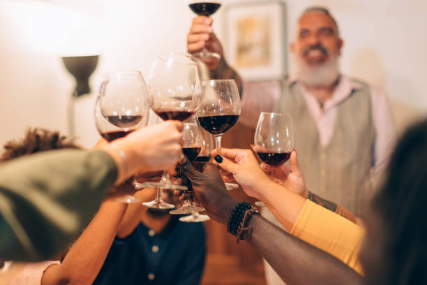 istock clinking glasses at the dinner - hands cheering with wine 1476836076
