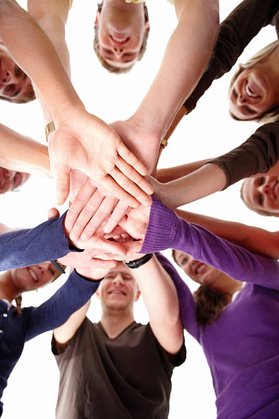 istock Group of young men and women joining hands 147684701