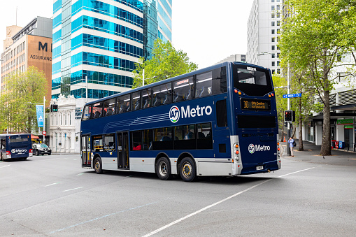 This 25 October 2022 daytime photo shows an AT Metro Bus in Tāmaki Makaurau Auckland, Aotearoa New Zealand. This photo shows a double decker bus operating as route 30 toward City Centre and was taken at the intersection of Queen St and Mayoral Dr. Auckland Transport manages public transportation around the super city.