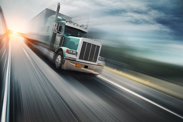 Truck on freeway American truck speeding on freeway, blurred motion. trucking stock pictures, royalty-free photos & images