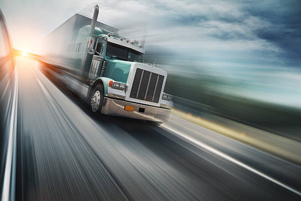 Truck on freeway American truck speeding on freeway, blurred motion. semi truck stock pictures, royalty-free photos & images