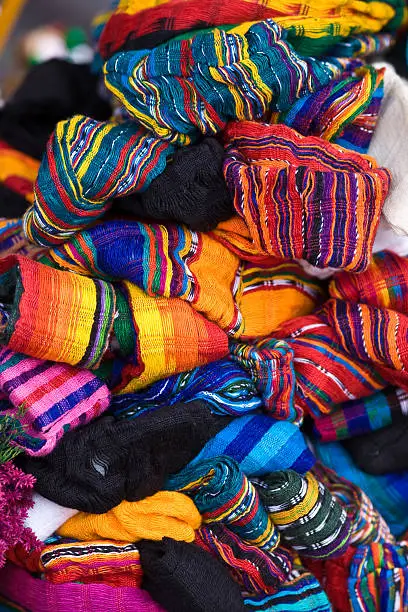 Colorful scarves piled on a street merchant's table in Mexico