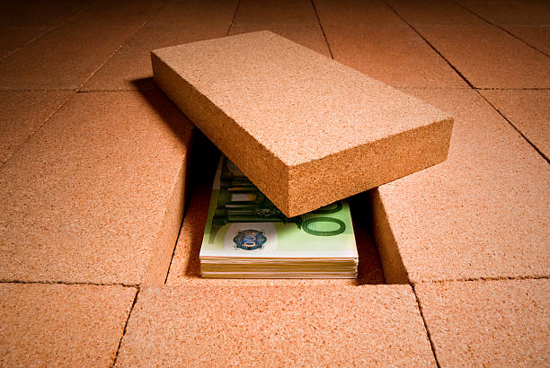 Cash hiding under a brick in the floor stock photo