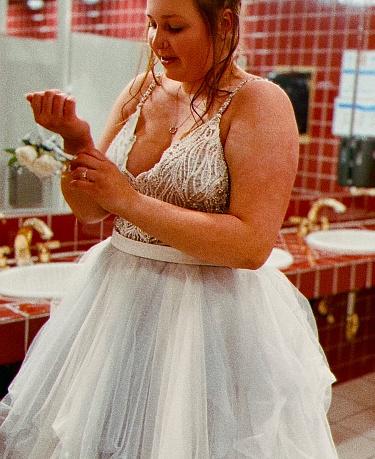 A high school girl on prom night in prom attire, putting on the finishing touches for the night in the bathroom mirror.Pembine, Wisconsin.