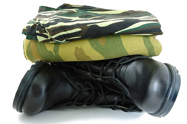 Camouflage uniform and two army boots. stock photo