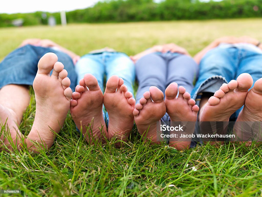 Von Teenagern, die Füße liegen auf grünem Gras im Feld - Lizenzfrei Fußsohle Stock-Foto