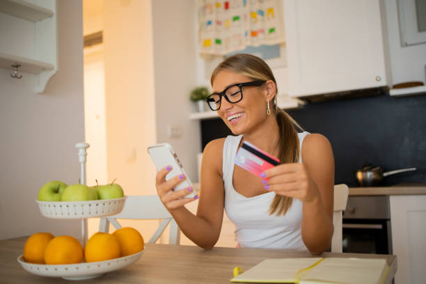 istock Cheerful  woman doing online shopping 1476886737