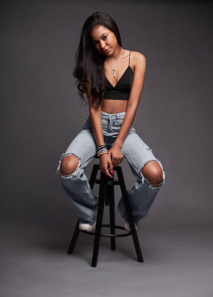 istock Trendy Hispanic woman sitting on stool 1476888652