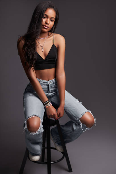 istock Trendy Hispanic female model sitting on stool 1476888660