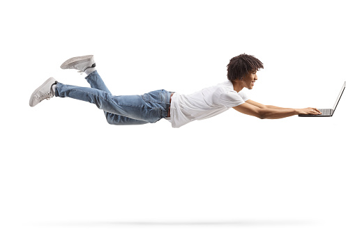 African american young man flying and using a laptop computer isolated on white background