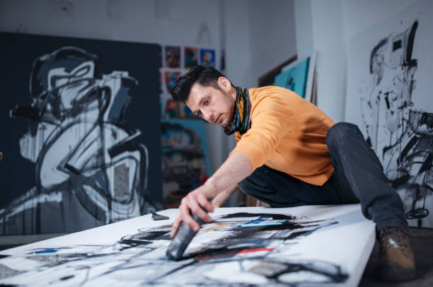 istock Artist painting canvas on the floor in studio. 1476896214
