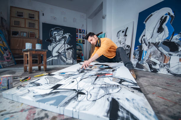 istock Artist working on his painting in art studio. 1476896223
