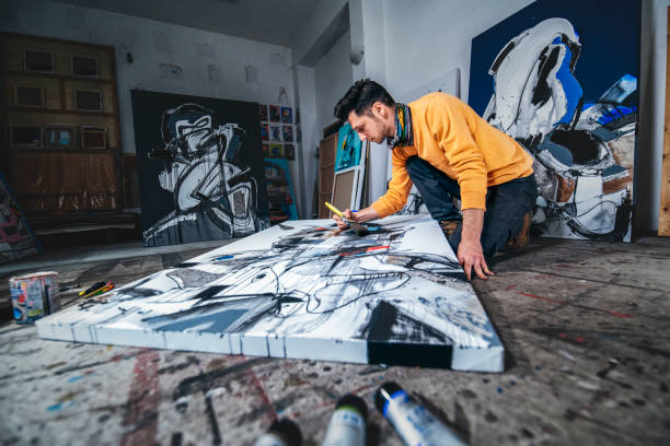 istock Artist painting canvas on the floor in studio. 1476896803