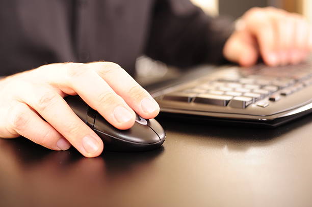 A person using a keyboard and a mouse stock photo