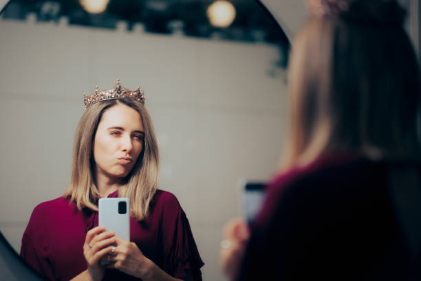 mujer narcisista que se siente importante mientras toma selfies en el espejo - elitist fotografías e imágenes de stock