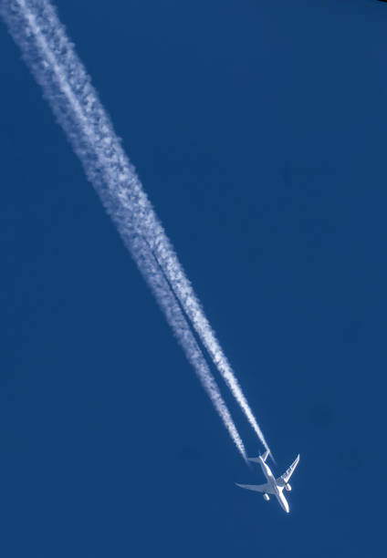 istock Jet streaks across a clear blue sky 1476903122