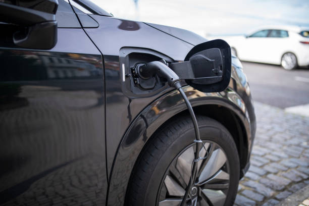 istock Plugged in electric car into charging station. 1476903571