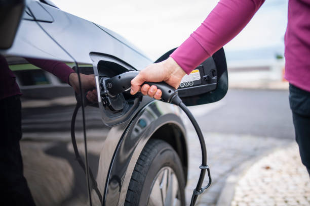 istock Man plugging the charging cable into his electric car. 1476903585